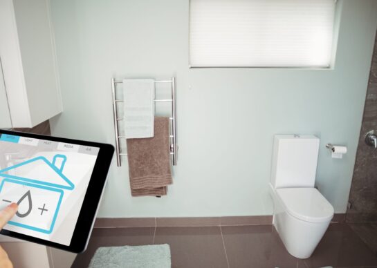 Digital composite of Hand using smart home application on digital tablet in washroom